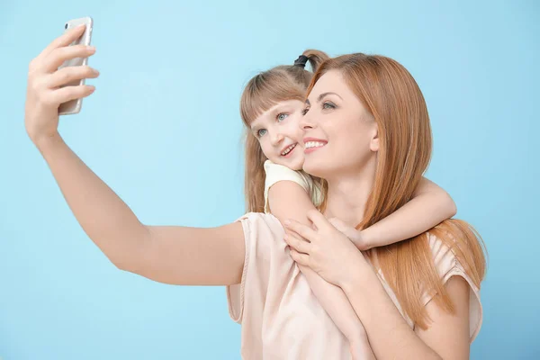 Mujer Pequeña Hija Tomando Selfie Sobre Fondo Color — Foto de Stock