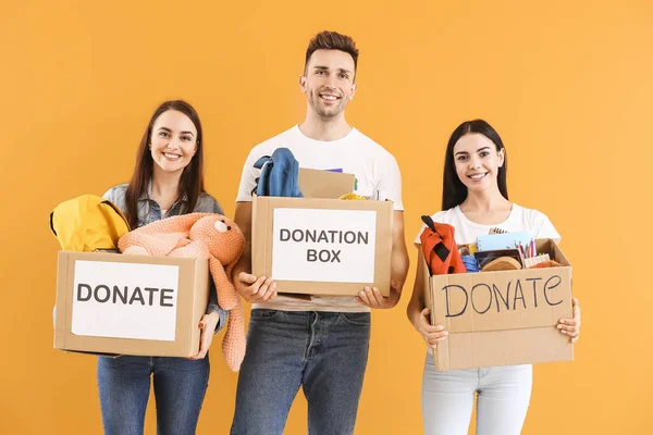 Voluntarios Con Donaciones Para Huérfanos Sobre Fondo Color — Foto de Stock