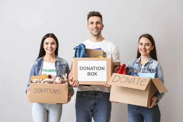 Freiwillige Mit Spenden Für Waisenkinder Vor Grauem Hintergrund — Stockfoto