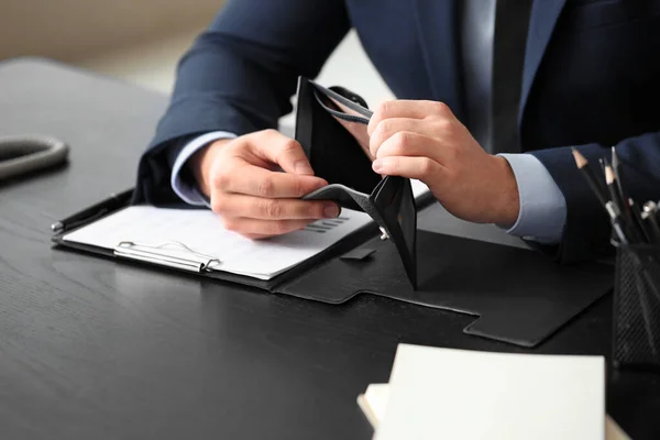 Businessman with empty purse in office, closeup