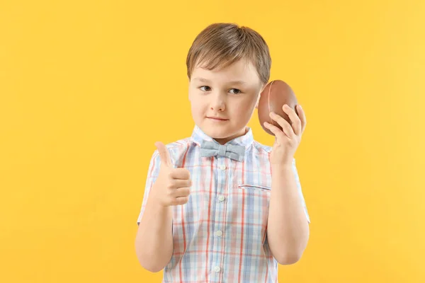 Χαριτωμένο Μικρό Αγόρι Γλυκό Αυγό Σοκολάτας Δείχνει Αντίχειρα Στο Φόντο — Φωτογραφία Αρχείου