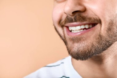 Handsome smiling young man on color background, closeup