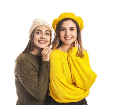 Beyaz arka planda kalın kazaklı genç kadınlar.