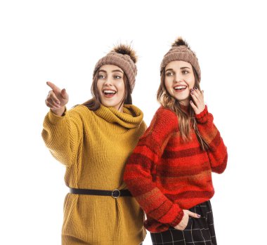 Beyaz arka planda kalın kazaklı genç kadınlar.