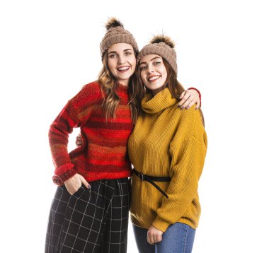 Beyaz arka planda kalın kazaklı genç kadınlar.