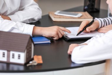 Ofiste müşterilerle çalışan küçük bir emlakçı.