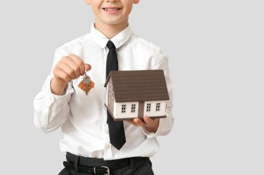 Arka planda ev modeli olan küçük bir emlakçı.