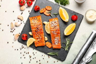 Pişmiş somon filetosu ve hafif arka planda sebze tabağı.