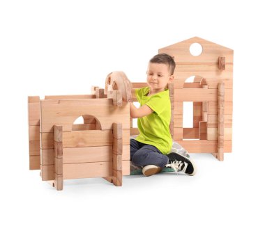 Küçük çocuk beyaz arka planda paravan evle oynuyor.