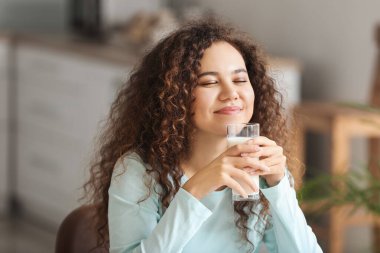 Mutfakta sütü olan genç Afro-Amerikalı kadın.