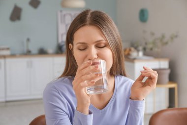 Evinde su içen güzel genç bir kadın.