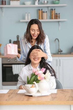 Yetişkin kız, annesini evde selamlıyor.