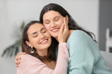 Yetişkin kızı annesiyle evde vakit geçiriyor.