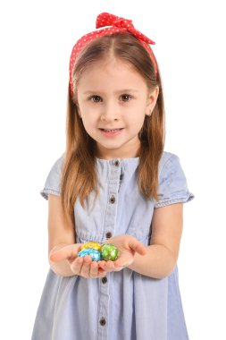 Beyaz arka planda çikolata yumurtaları olan tatlı küçük bir kız.