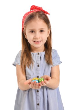 Beyaz arka planda çikolata yumurtaları olan tatlı küçük bir kız.