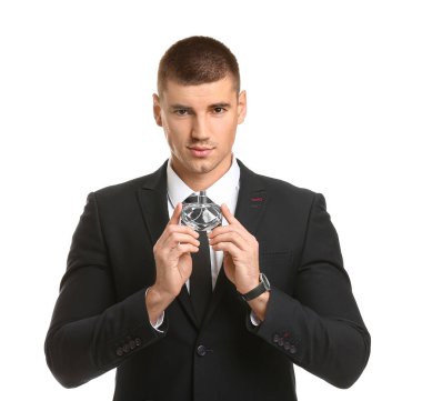 Beyaz arka planda parfüm şişesi olan yakışıklı bir genç.