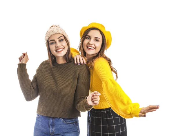 Beyaz arka planda kalın kazaklı genç kadınlar.