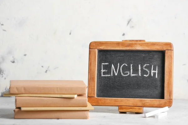 テキスト付きの黒板テーブルの上の英語と本 — ストック写真