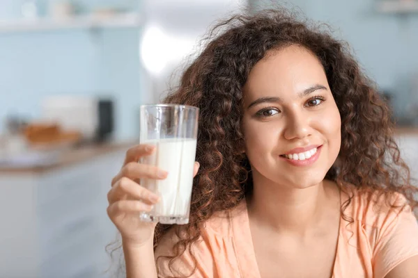 在厨房里喝牛奶的年轻非洲裔美国妇女 — 图库照片