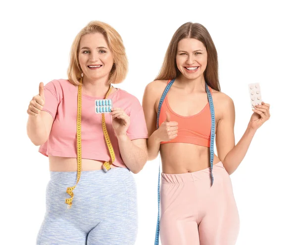 Beyaz arka planda kilo verme hapları olan kadınlar