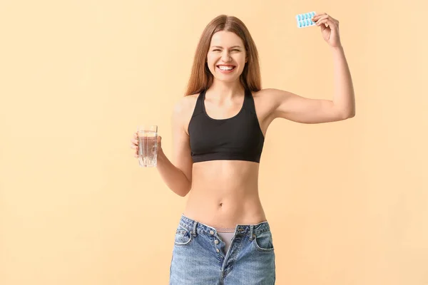 Frau Lockerer Jeans Und Mit Gewichtsverlust Pillen Auf Farbigem Hintergrund — Stockfoto