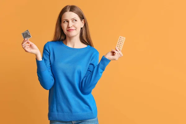 Mujer Joven Con Píldoras Anticonceptivas Condón Sobre Fondo Color — Foto de Stock