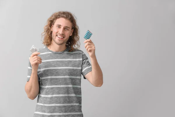 Young Man Oral Erectile Dysfunction Medication Condom Grey Background — Stock Photo, Image
