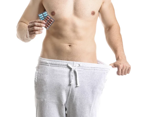 Hombre Joven Ropa Suelta Con Píldoras Pérdida Peso Sobre Fondo — Foto de Stock