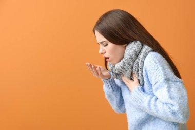 Renkli arka planda öksüren genç kadın