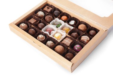 Beyaz arka planda lezzetli şekerlerle dolu bir kutu