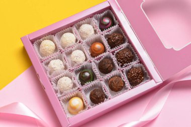 Renkli arkaplanda lezzetli şekerlerle dolu bir kutu