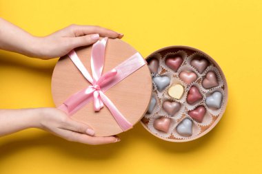 Renkli kutuda lezzetli şekerlemeleri olan kadın elleri