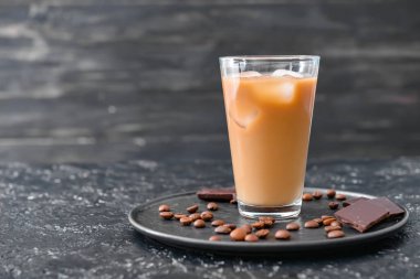 Koyu arkaplanda bir bardak buzlu kahve.