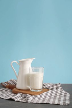 Masanın üzerinde bir bardak taze süt ve bir sürahi...