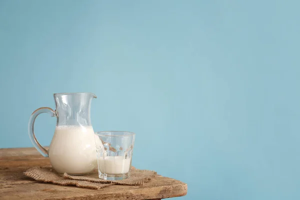 Vetreria Con Latte Fresco Sul Tavolo Contro Sfondo Colore — Foto Stock