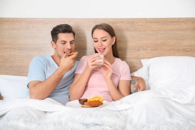 Genç çiftin yatakta kahvaltı ettiği bir sabah.