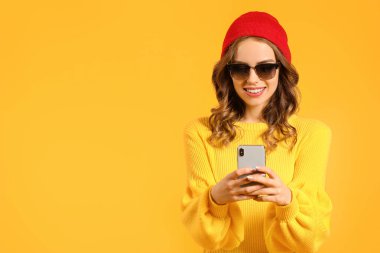 Arka planda cep telefonu olan genç bir kadın.