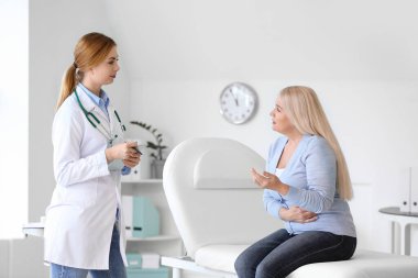 Olgun kadın klinikte doktoru ziyaret ediyor.