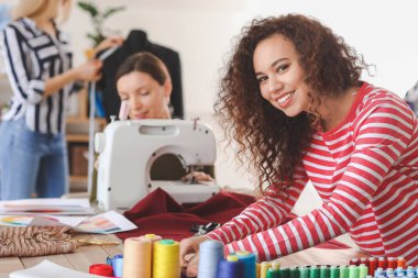 Atölyedeki terzi kursunda genç bir kadın.