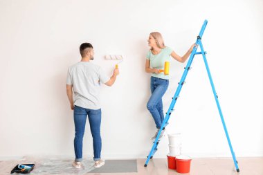 Evde duvar boyayan genç bir çift.