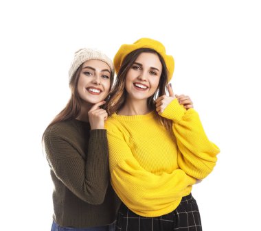 Beyaz arka planda kalın kazaklı genç kadınlar.