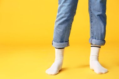 Çoraplı erkek bacakları ve renkli kot pantolon.