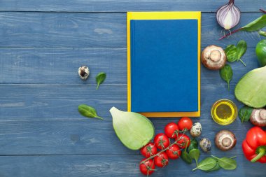 Renkli ahşap arka planda ürünleri olan yemek kitapları