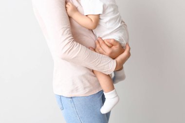 Hafif arka planda sevimli küçük bebek ile mutlu anne