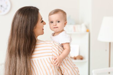 Mutlu anne ve evde küçük şirin bir bebek.