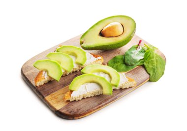 Beyaz arka planda lezzetli avokado sandviçleri olan tahta