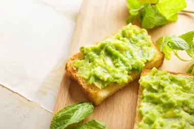 Masada lezzetli avokado sandviçleri olan bir pano.