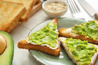 Masada lezzetli avokado sandviçli tabak.