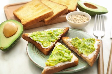 Masada lezzetli avokado sandviçli tabak.