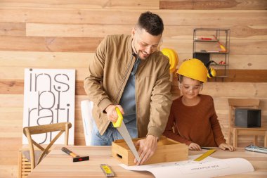 Küçük oğlu marangoz atölyesinde babasına yardım ediyor.